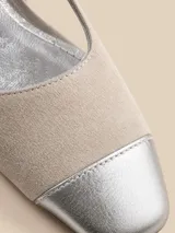 Zapato destalonado de gamuza color arena, con puntera de cuero metalizado plateado, tira en el empeine y taco cuadrado bajo.