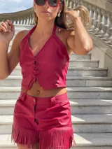 Short de cuero sintético color fucsia con flecos en el ruedo.