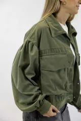Campera corta de pana color verde militar, con bolsillos frontales con solapa, mangas abullonadas y cierre frontal de botones metálicos.