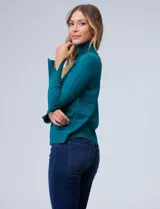 Polera de tejido fino, color rosado, con cuello alto, manga larga y detalle de tajo en los puños.