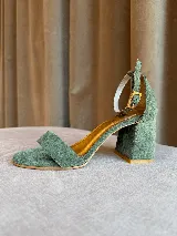 Sandalia de tacón cuadrado medio, confeccionada en tela tipo terciopelo color bordó, con tira delantera simple y pulsera ajustable al tobillo con hebilla metálica.