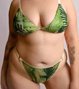 Bombacha tipo colaless de tiro medio, confeccionada en lycra estampada con diseño de hojas tropicales. Presenta terminaciones con puntilla decorativa en los bordes y breteles elásticos regulables en los laterales.