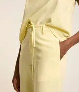 Pantalón wide leg color amarillo pálido, confeccionado en sarga leve, con cintura alta y cordón de ajuste.