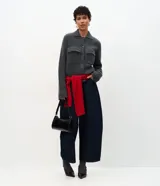 Campera de punto con textura, corte recto y cuello clásico. Presenta cierre frontal con botones y dos bolsillos aplicados con solapa en el pecho.