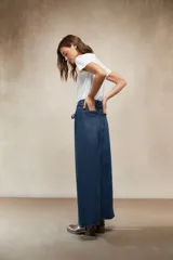 Falda larga de denim color marrón chocolate, tiro alto, con lazo de ajuste en la cintura y abertura frontal pronunciada.