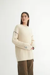 Sweater tejido de punto color ladrillo, con cuello redondo y calce oversize.