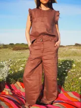 Pantalón de jean color celeste claro, de corte ancho y relajado, con cintura alta, trabillas para cinto y un botón frontal visible.
