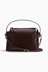 Cartera cruzada color bordó con asa superior y cierre. Cuenta con correa ajustable y extraíble, trabillas con hebilla metálica en los laterales y forro interior.