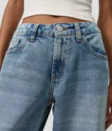 Pantalón wide leg de tiro bajo confeccionado en jean de algodón, con diseño de piernas amplias y bolsillos delanteros y traseros.