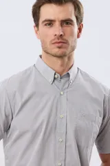 Camisa sport celeste de manga corta con cuello abotonado y bolsillo frontal en el pecho.