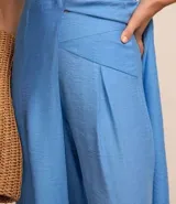 Pantalón alladin celeste de crepé, con cintura cruzada, pliegues y bajo ajustado.