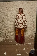 Sweater de lana tejido a mano con diseño geométrico en tonos marrón y beige, de calce holgado, cuello redondo y puños ajustados.