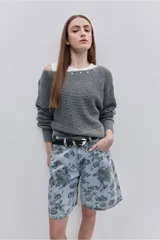 Sweater de punto color tostado, de calce relajado, con escote asimétrico decorado con ojalillos metálicos y mangas largas.