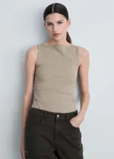 Musculosa color beige de tejido elástico y diseño entallado, con cuello barco y tirantes anchos.
