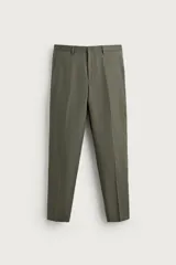 Pantalón de traje regular fit de lino color verde militar, con bolsillos laterales y bolsillos traseros de doble vivo con botón. Cierre frontal con cremallera y botón.