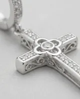Caravanas de plata 925 con diseño de cruz colgante, adornadas con circonias brillantes. Cuentan con un cierre tipo pasante clip.