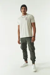 Pantalón cargo verde militar con puños elásticos, bolsillos laterales con solapa y bolsillos traseros.