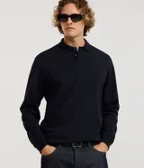 Buzo de algodón azul marino con cuello polo y cierre frontal de botones, de manga larga con puños ajustados y diseño liso.