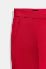 Pantalón capri de vestir color rojo, de corte slim, tiro alto, con pinzas delanteras, bolsillos laterales y falsos bolsillos traseros.