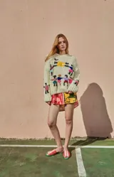 Sweater tejido de lana color crudo, con cuello redondo, puños ajustados y bordado artesanal con figuras de personas tomadas de la mano.