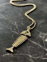 Collar compuesto por una cadena fina de plata 925 con baño de oro 18k y un dije en forma de espina de pescado decorado con mini circonias.