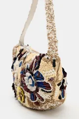 Bolso de mano con cuerpo cubierto de abalorios y apliques florales bordados, con asa corta y cierre de cremallera.