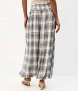 Pantalón de viscosa estilo aladín con estampado a cuadros en tonos grises, blancos y azules. Presenta cintura elástica fruncida y puños ajustados en los tobillos de corte ancho.