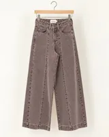 Pantalón de denim estilo wide leg color gris topo, con tiro alto, bolsillos delanteros, costuras frontales verticales y botamanga ancha.