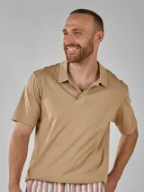 Remera color beige de manga corta y cuello polo con dos botones.