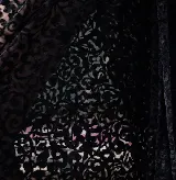 Top de encaje de terciopelo negro con diseño de arabescos, de manga larga y cierre frontal con lazos.