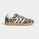 Championes Adidas Samba OG con diseño de estampado animal print tipo jirafa en tonos marrón y blanco. Presenta las icónicas tres bandas laterales en color blanco, cordones en celeste y suela de goma color caramelo.
