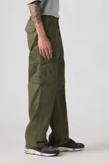 Pantalón cargo holgado color verde militar, con bolsillos laterales y perneras anchas.
