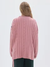 Buzo tejido de punto color beige, con cuello subido, diseño oversized y aberturas laterales en el ruedo.