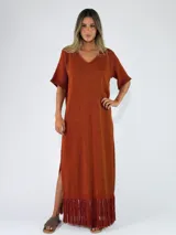 Vestido largo de tejido de punto color bordó, con cuello en V, mangas cortas amplias, aberturas laterales en el bajo y flecos colgantes en el ruedo.