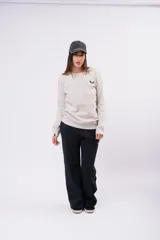 Buzo de cuello redondo y manga larga, confeccionado en tela suave y cómoda. Presenta un diseño minimalista con un pequeño logo bordado en el pecho y puños acanalados.