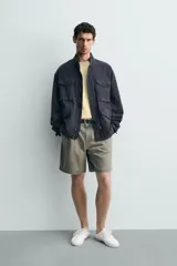 Cazadora regular fit de algodón color gris oscuro con efecto lavado, cuello subido, manga larga y cierre frontal con cremallera oculta por solapa con botones a presión. Cuenta con cuatro bolsillos frontales de plastrón con solapa y cintura ajustable con cordón interior.