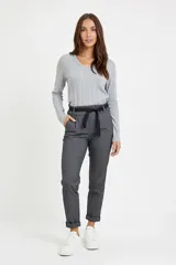 Pantalón de corte recto en color gris, confeccionado en tejido con textura. Presenta cintura elástica con lazo ajustable, bolsillos laterales y dobladillo en los tobillos.