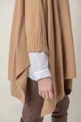 Poncho italiano color beige, de abrigo, liso con detalle de guarda lateral en el mismo tono.