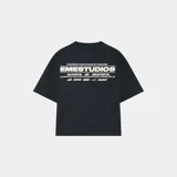 Camiseta negra de corte cuadrado con estampado en la espalda con el texto "POWERED BY GRATITUDE, BUILT TOGETHER", "EMESTUDIOS", "ALWAYS GRATEFUL" y otros textos y logos de la marca.