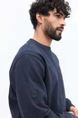 Buzo de algodón azul marino, corte regular, con cuello redondo. Presenta un bordado de flores y texto en el pecho.