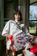 Short unisex de corte holgado con cintura elástica y estampado a cuadros rojos y blancos con dibujos de frutas.