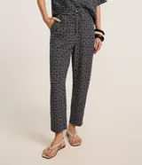 Pantalón carrot de crepé con cintura alta, estampado geométrico en blanco y negro, y lazo en la cintura.
