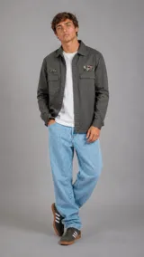 Sobrecamisa de gabardina color gris oscuro, con cierre frontal de botones, bolsillos frontales con solapa y parches decorativos en el pecho.