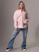 Camisa de popelín de algodón color rosa claro, de corte holgado, con cuello clásico, cierre frontal con botones, bolsillo de parche en el pecho y puños abotonados.