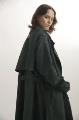 Trench largo de corte oversize en color azul marino, con solapas amplias, cierre frontal de doble botonadura y detalles de trabillas en los hombros y puños.