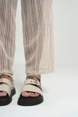 Pantalón de tejido calado color crudo, con cintura elástica y corte palazzo.