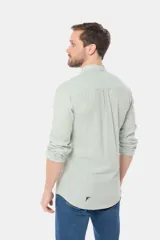 Camisa de lino color verde claro, con cuello mao, manga larga y botones personalizados.