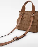 Mini cartera tipo city bag Adolfo Domínguez modelo Auge II de cuero vacuno marrón con estampado efecto croco. Cuenta con una solapa con cierre magnético y asa de mano estructurada.