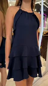 Vestido corto azul marino con escote halter y volados en cascada en la falda.