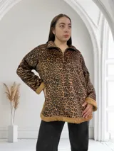 Buzo de micropana con estampado animal print, cuello polo con cierre de cremallera metálica dorada y puños y ruedo con ribete de corderito color beige.